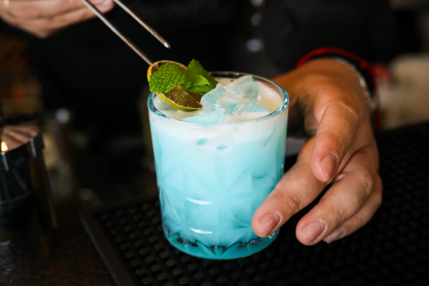 Bartender preparando o drink autoral Let It Blue no Music Box