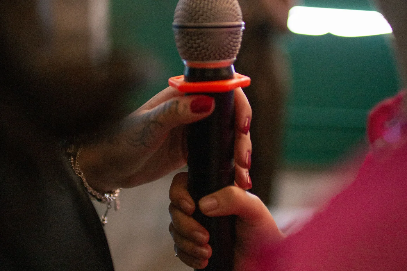 Pessoa segurando o microfone para cantar em um camarote do Music Box