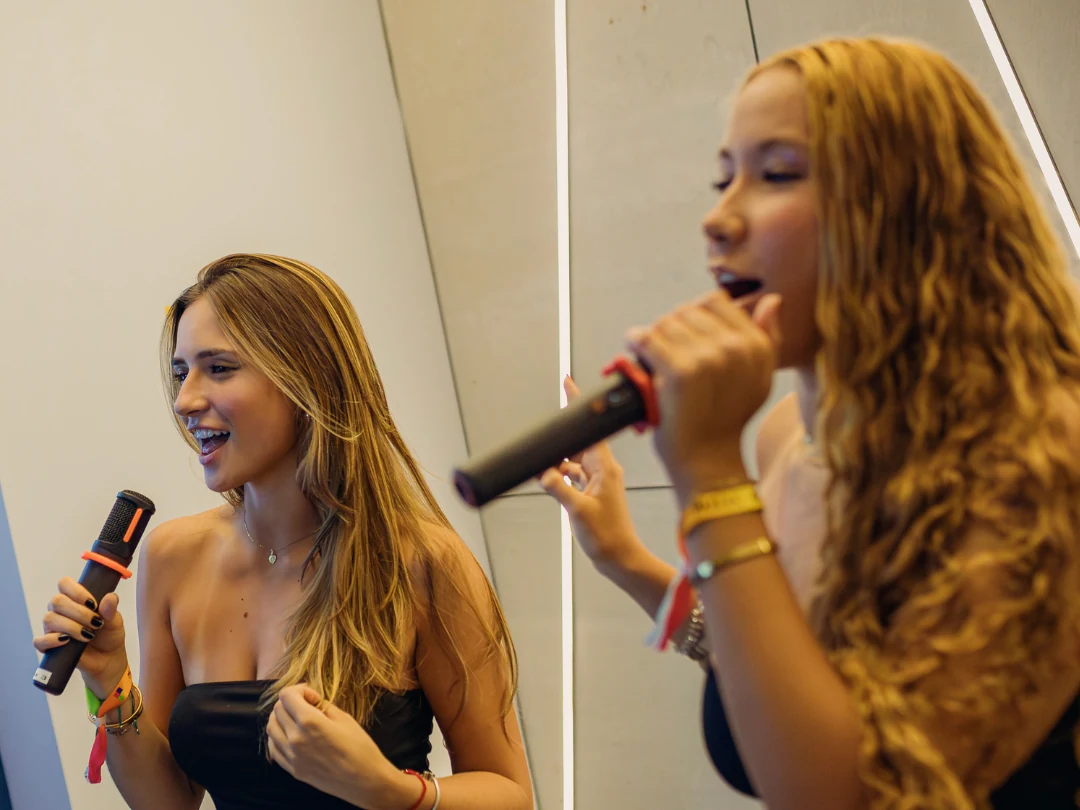 Duas amigas cantando juntas no microfone