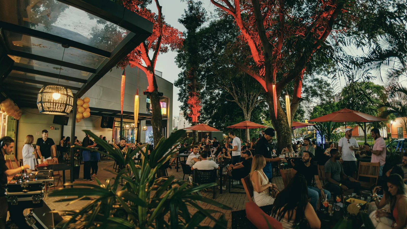 Área externa do bar do Music Box, com mesas ao ar livre e clima de happy hour